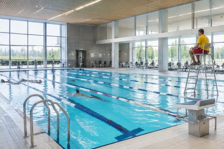 Helles Hallenbad mit Schwimmbecken und Aufsichtsstation – generiertes Motiv